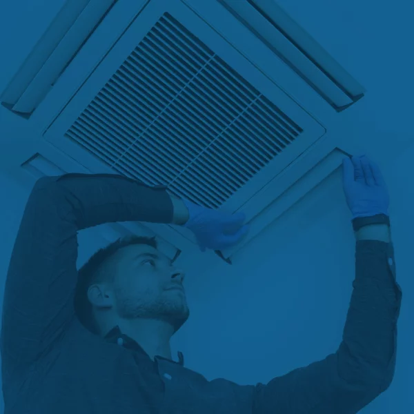 Technicien retirant la grille d'un diffuseur de plafond résidentiel