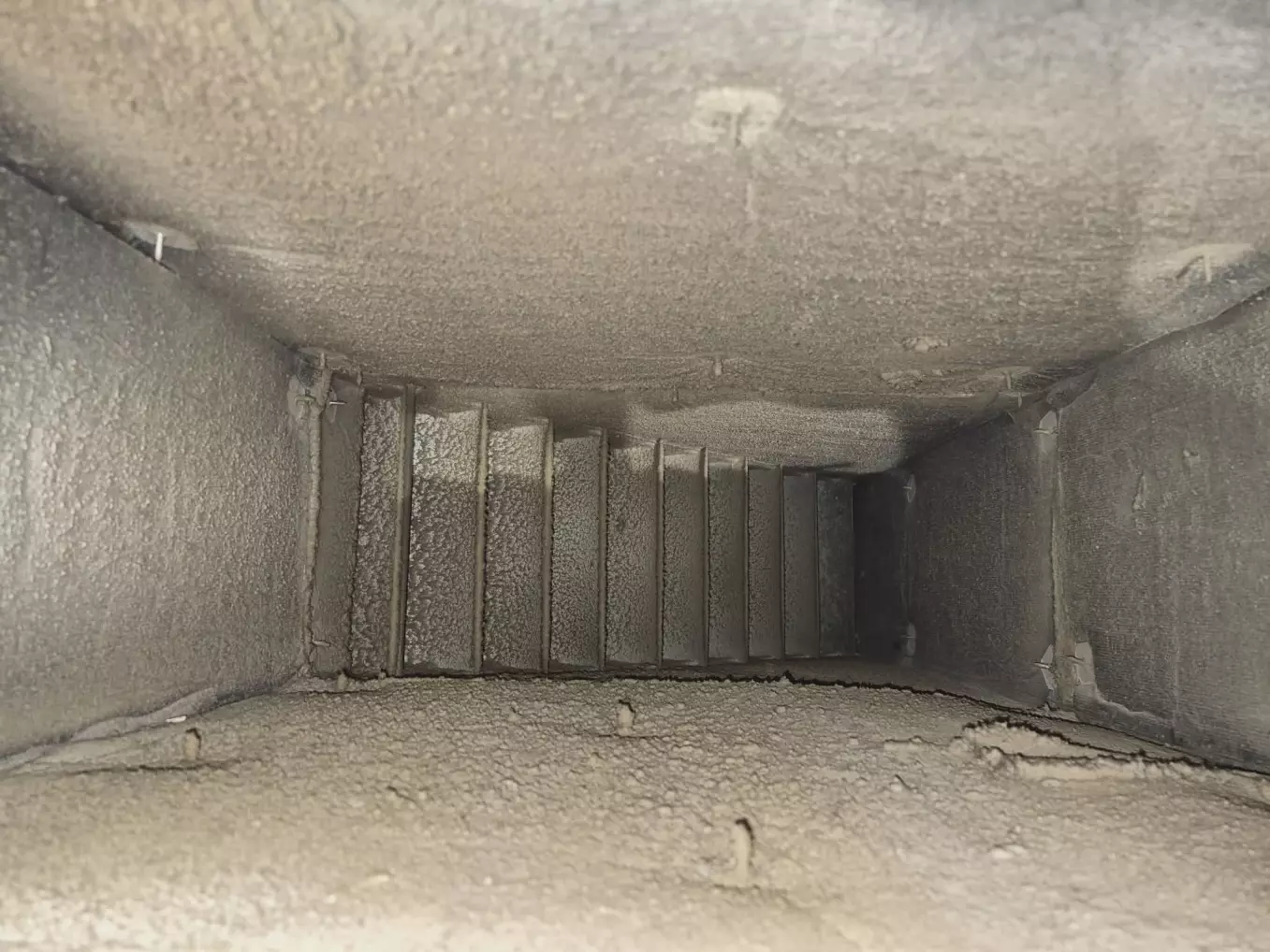 Conduit de ventilation industriel encrassé de poussière avant le nettoyage