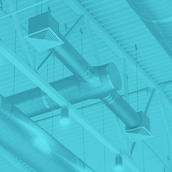 Conduits de ventilation apparents sous la toiture d'un bâtiment industriel